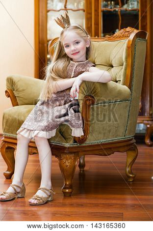 Little girl with crown on the chair