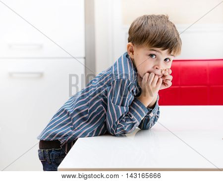 The boy in the kitchen at the table