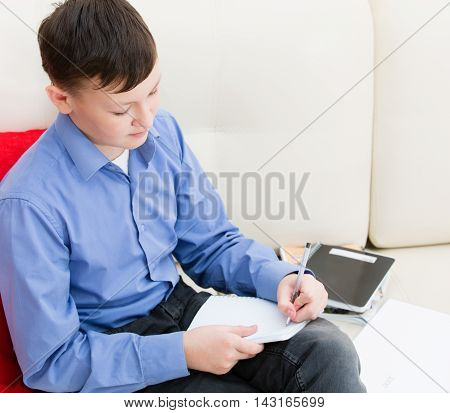 The Boy Is Left-handed Writing In A Notebook