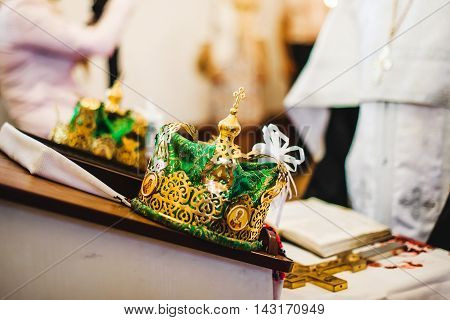 Two beautiful gold wedding crowns in church