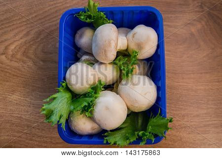 mushrooms and salad in the blue box on the table