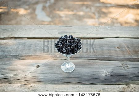 organic blackberries in a glass on a gray wooden board, rustic, detox, selective focus