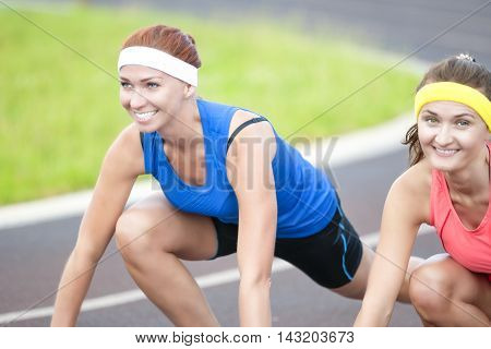 Portrait of Two Pretty Caucasian Sportswomen Having Fun Time At Sport Venue Outdoors.Horizontal Image