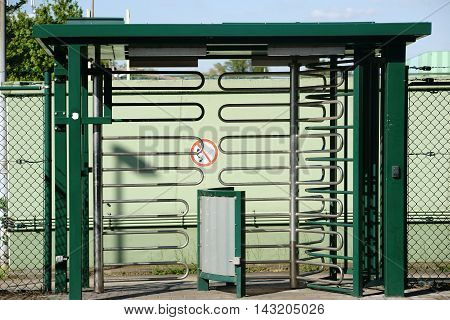 A rotary entrance from u-shaped bent metal pipes to an industrial area.