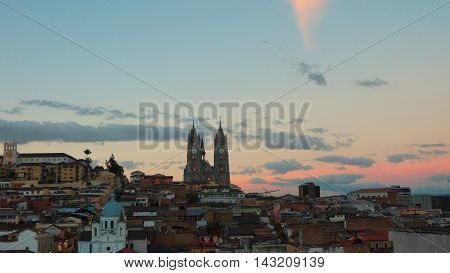 Quito Pichincha / Ecuador - August 16 2016: Sunset on historic center of Quito with Basilica del Voto Nacional in background. It was declared by UNESCO the first Cultural Heritage on 1978