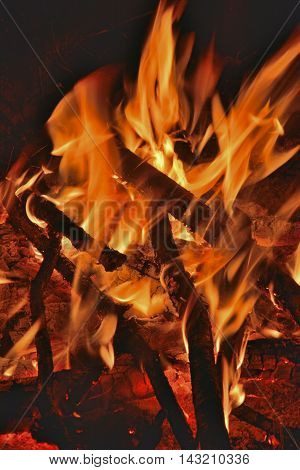 A close up of the aflame wood in bonfire.
