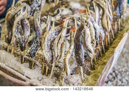 Fish with salt being grilled outdoors in Japan