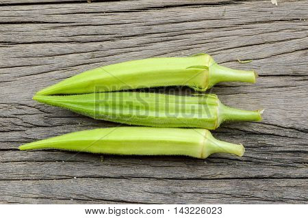 close up fresh green Okra on wooden floor - Abelmoschus esculentus