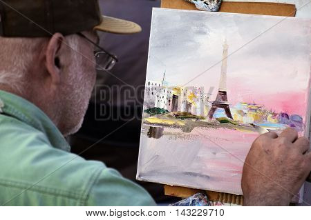 PARIS FRANCE - APRIL 20 2015: An artist drawing at Place du Tertre an open-air workshop with its 288 official painters on Montmartre