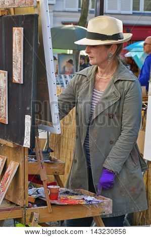 Paris, France - April 20, 2015: An Artist Drawing At Place Du Tertre, An Open-air Workshop With Its