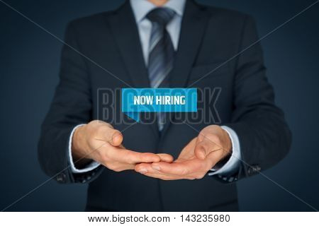 Now hiring - human resources concept. Businessman (recruiter HR staffer) hold virtual label with text now hiring.