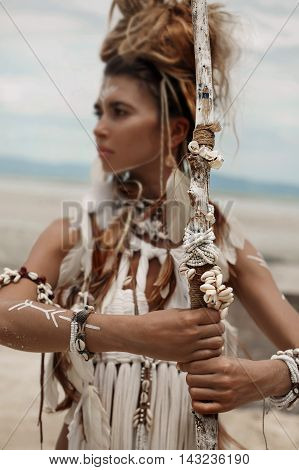 Attractive wild boho woman in white tribal dress portrait