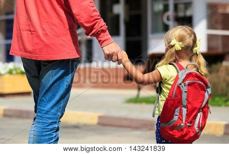 father walking little daughter to school or daycare, back to school