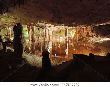 Illuminated subterranean lake in a dripstone cave.