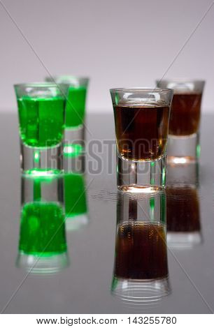 Four cups of alcohol to drink on grey background