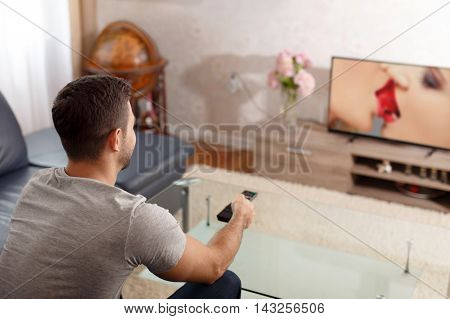 Man watching sex movie in TV on adult channel