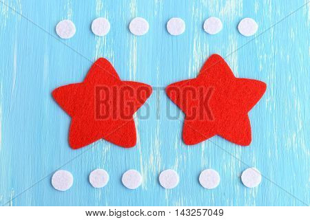 Cut red and white felt details to create Christmas star decor. Fun craft technique for children. Step-by-step. Christmas star tutorial. Blue background. Top view. Closeup