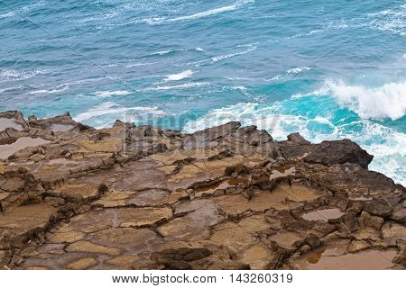 Deep blue sea water splashing volcanic rock at blowholes at Cape Bridgewater in Victoria, Australia
