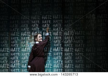 Portrait of a young smiling girl in school uniform as killer woman against school board . The image in the style of Halloween and Addams family