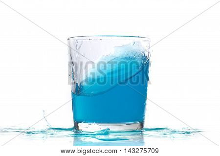 Blue liquid in a low glass oon white background