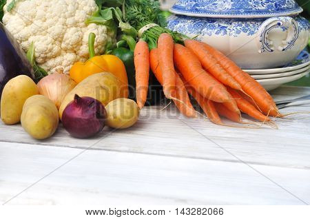 vegetables for potage on a white table with bowl and tablespoon