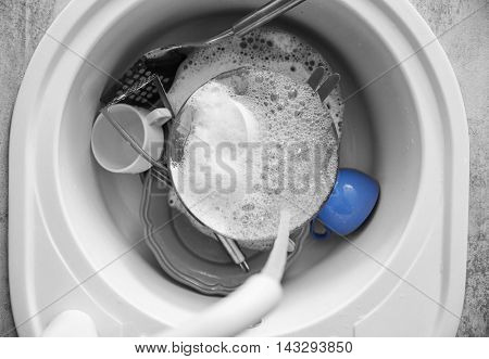 Dirty tableware in white sink at kitchen