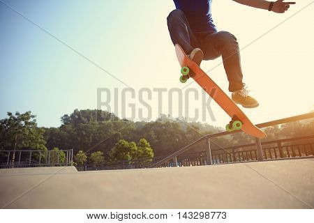 one young skateboarder skateboarding at sunrise skatepark