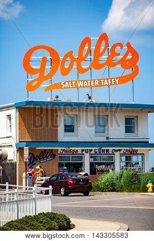 Rehoboth Beach DE - June 25 2013: The big orange Dolles Salt Water Taffy sign on top of the candy shop has become a Delaware landmark.