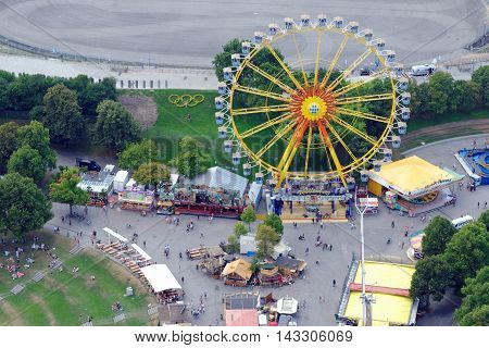 MUNICH GERMANY - 4 AUGUST 2015: Ferris Wheel in a fun fair on the grounds of the Olimpiapark near Olympia Tower.