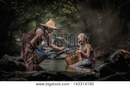 Old Asian woman working in cascade Thailand