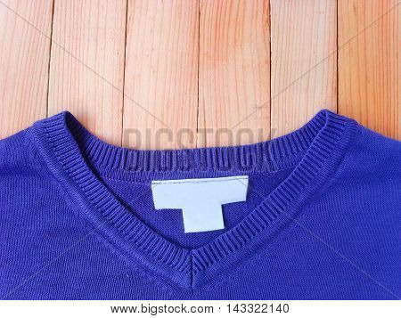 Men `s sweater. There tag advertising space on a wooden background