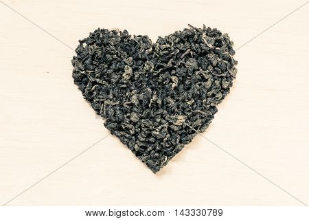 Diet healthcare concept. Green tea heart shaped on wooden surface. Healthy food drink for lower heart disease risk