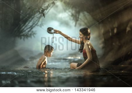 Sister and brother bathing in cascade Thailand