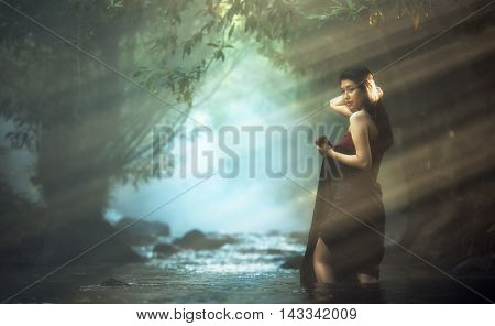 Beautiful Asian woman in cascade, countryside of Thailand