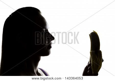 Young amazed woman in lacy lingerie holding a banana, she is going to eat a banana. she sucks a banana.