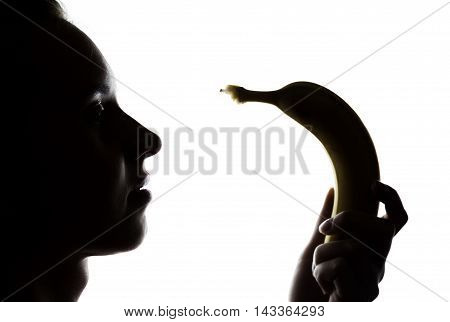 Young amazed woman in lacy lingerie holding a banana, she is going to eat a banana. she sucks a banana.