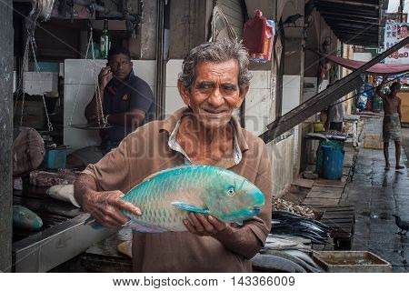 Galle Sri Lanka 28 May 2016. The seller offers to buy the big blue fish to passersby.