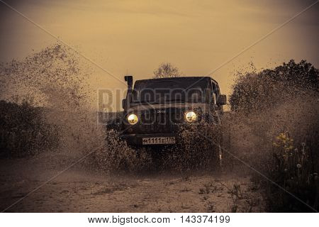 Novgorod oblast, Russia , 03 August, 2015 , Jeep Wrangler on a rural road in the Novgorod region, the Jeep Wrangler is a compact four wheel drive off road and sport utility vehicle