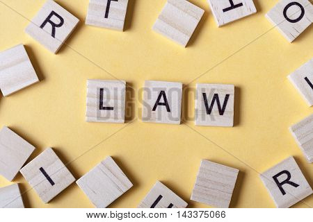Law word written on wood block. Woodwn abc.