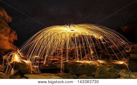 fire show, dancing with flame, male master fakir blowing fire, performance outdoors, flame control man dances with fire, with fire trails on a background draws a fiery figure in the dark