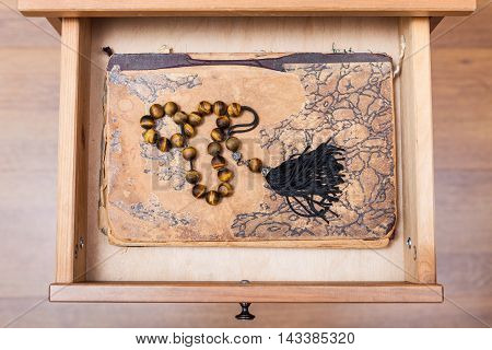 Rosary On Ansient Book In Open Drawer