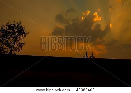 Silhouette cyclist with reflection at sunset .