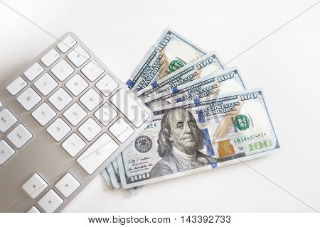 Concept image of finance and investment. 100 US dollars bank notes and money coins. with computer keyboard.