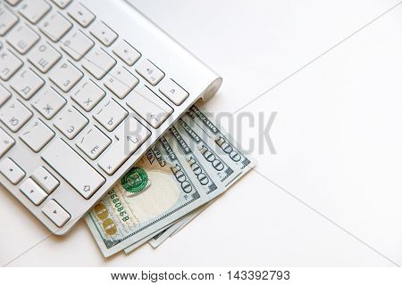 Concept image of finance and investment. 100 US dollars bank notes and money coins. with computer keyboard.