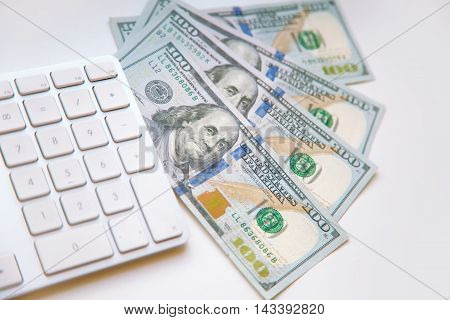 Concept image of finance and investment. 100 US dollars bank notes and money coins. with computer keyboard.