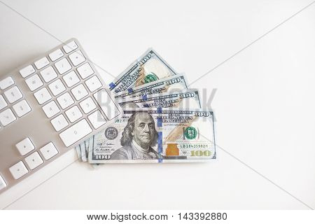 Concept image of finance and investment. 100 US dollars bank notes and money coins. with computer keyboard.