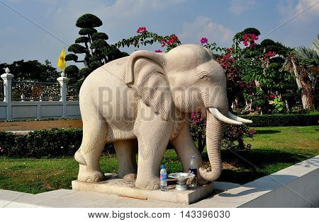 Samut Prakan Thailand - January 15 2013: Statue of a revered Thai elephant complete with two plastic bottles of water left as offerings at Wat Asoke