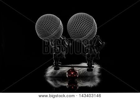 Two microphones and shields against black background