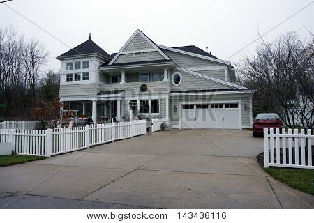 WEQUETONSING, MICHIGAN / UNITED STATES - DECEMBER 22, 2015: A large home with a white picket fence and an attached garage on Pennsylvania Avenue in Wequetonsing.