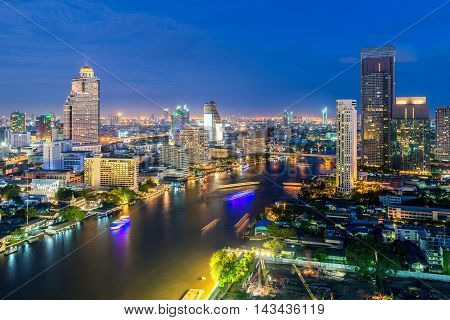 Bangkok skyline along Chao Phraya river at night in Bangkok Thailand.